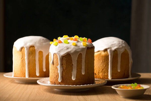 Three ruddy Easter cakes with white glaze on a dark background