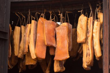 Tütsülenmiş domuz eti tütsüleme evinde bir ipe tutunur.