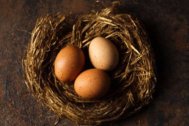 Büyük kırmızı yumurtalar kırsal tarzda altın bir yuva fotoğrafı.