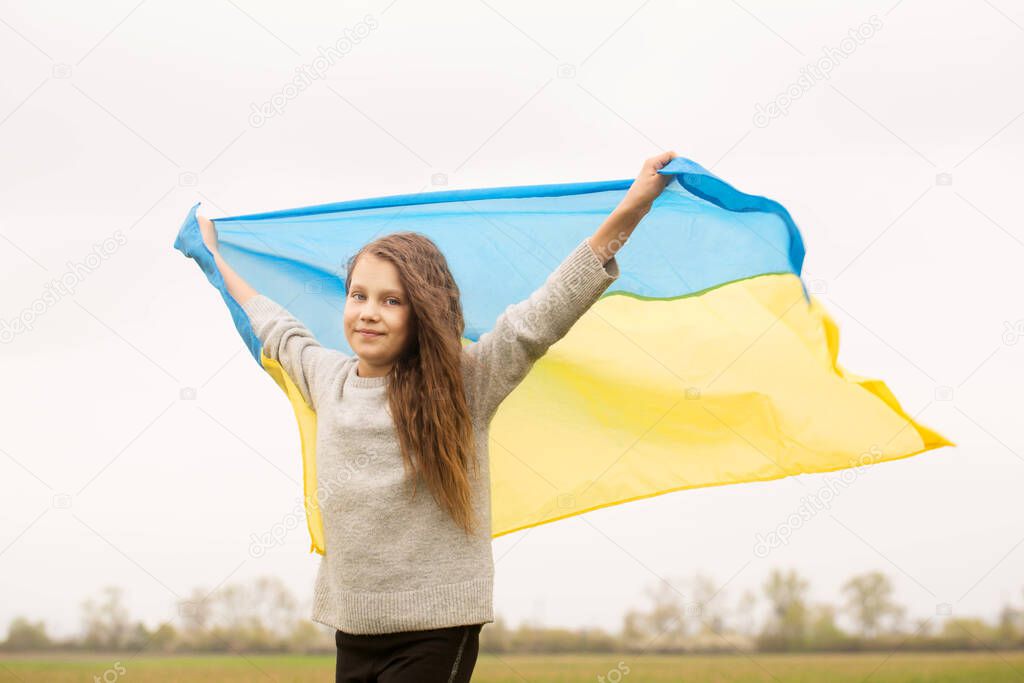 Happy girl with the Ukrainian flag in her hands
