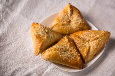 Susam tohumları serpiştirilmiş suluguni peynirli turtalar.