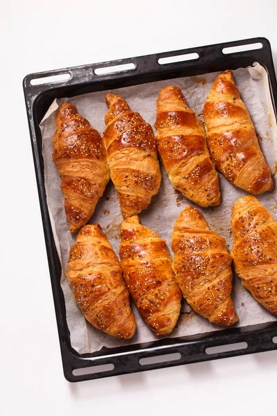 Velké Croissanty Kovových Pečicích Prostěradlech Bílém Pozadí Horní Pohled — Stock fotografie