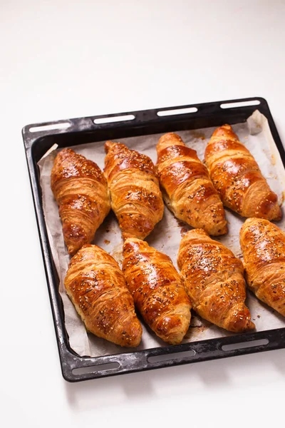 Velké Croissanty Kovových Pečicích Prostěradlech Bílém Pozadí Horní Pohled — Stock fotografie