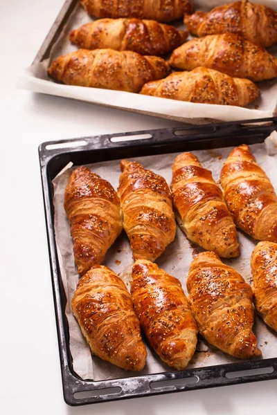 Velké Croissanty Kovových Pečicích Prostěradlech Bílém Pozadí Horní Pohled — Stock fotografie