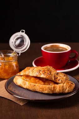 Sabah kahvesi ve turuncu reçelli gevrek kruvasan.