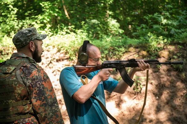 A Ukrainian civilian man is training to shoot an Akm machine gun during Ukraine\'s war with Russia