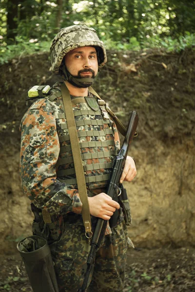 Portrait of a Ukrainian military man with a Kalashnikov assault rifle in his hands