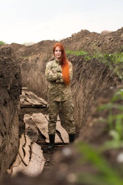 Ukrayna silahlı kuvvetleri üniformalı Ukraynalı kız siperde.