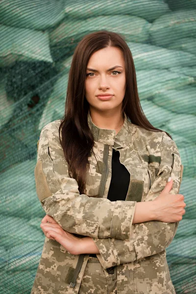 Ukrainian woman in the uniform of the armed forces of Ukraine on the background of sandbags