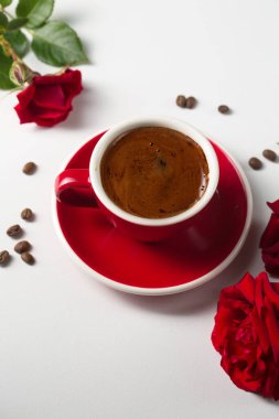 A cup of espresso with red roses