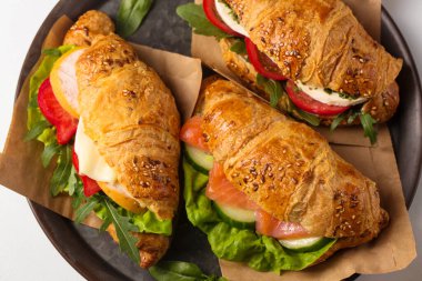 Three croissants with different salty fillings on a metal tray