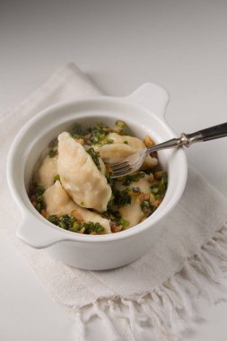 Potato dumplings with fried bacon and green onions