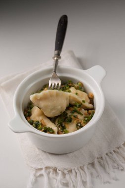 Potato dumplings with fried bacon and green onions