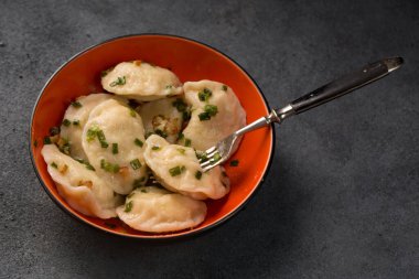 Potato dumplings with fried bacon and green onions