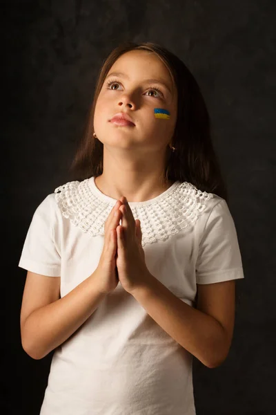 Little Girl Painted Ukrainian Flag Her Face Prays Ukraine Dark — Stok fotoğraf