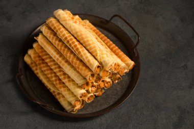 Ruddy crispy tubes with condensed milk on a metal tray