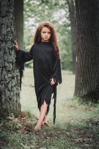 Mała Dziewczynka Kostiumie Czarownicy Lesie Przy Drzewie Koncepcja Halloween — Zdjęcie stockowe
