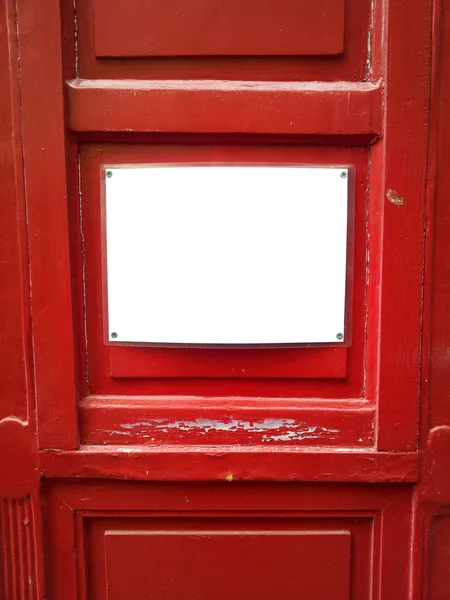 Empty board on red wooden door — Stock Photo, Image