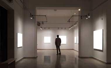 Man in gallery room looking at empty frames clipart