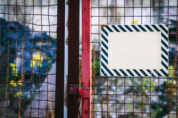 Empty warning metal sign on construction site door — Stock Photo, Image