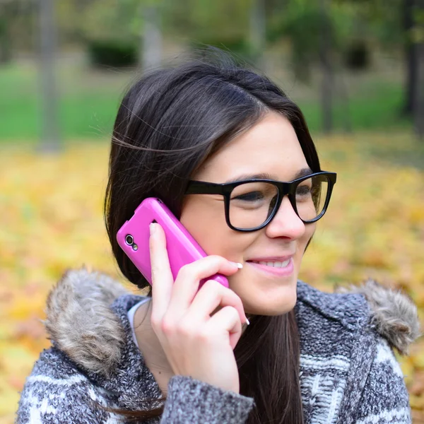 Schöne lächelnde Studentin, die auf dem Handy spricht — Stockfoto