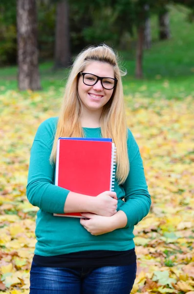 Linda menina estudante loira sorridente segurando livros — Fotografia de Stock