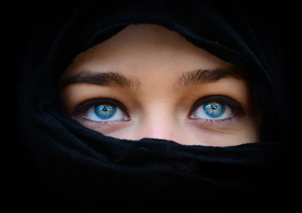 Linda mulher azul olhos atrás de cachecol preto olhando para cima — Fotografia de Stock