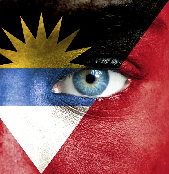 Human face painted with flag of Antigua and Barbuda — Stock Photo, Image