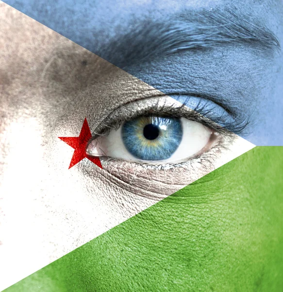 Human face painted with flag of Djibouti — Stock Photo, Image