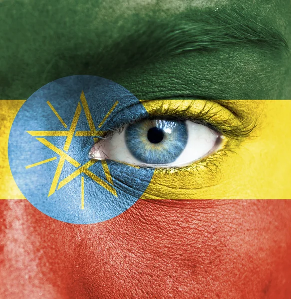 Menselijk gezicht beschilderd met vlag van Ethiopië — Stockfoto