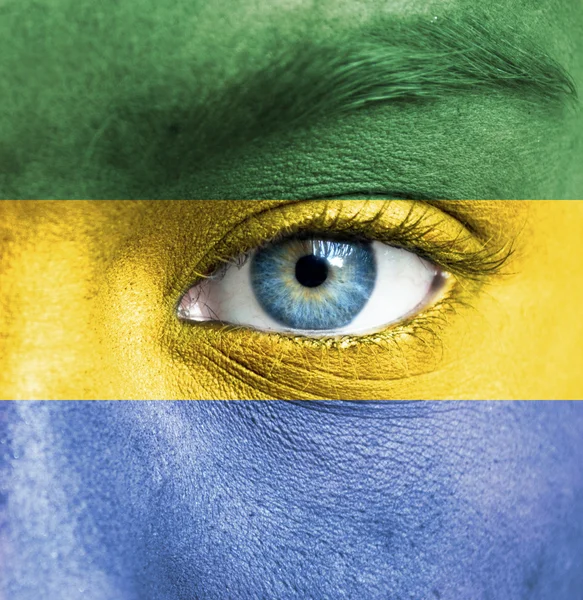 Human face painted with flag of Gabon — Stock Photo, Image