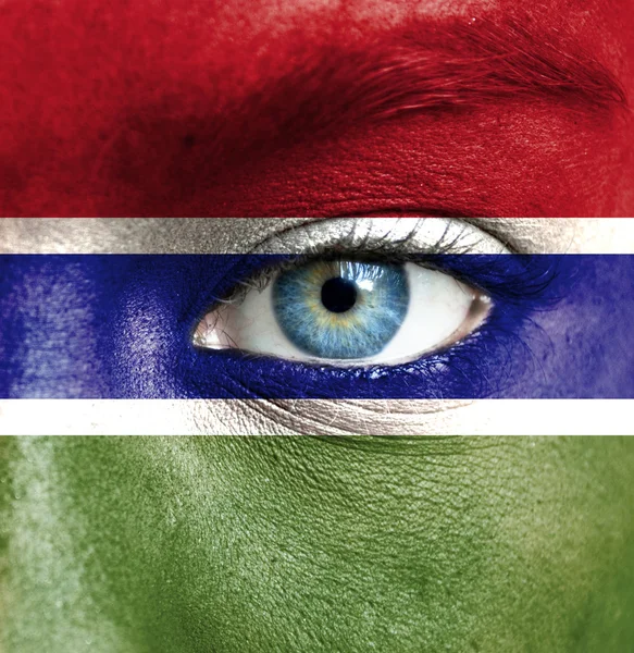 Human face painted with flag of Gambia — Stock Photo, Image