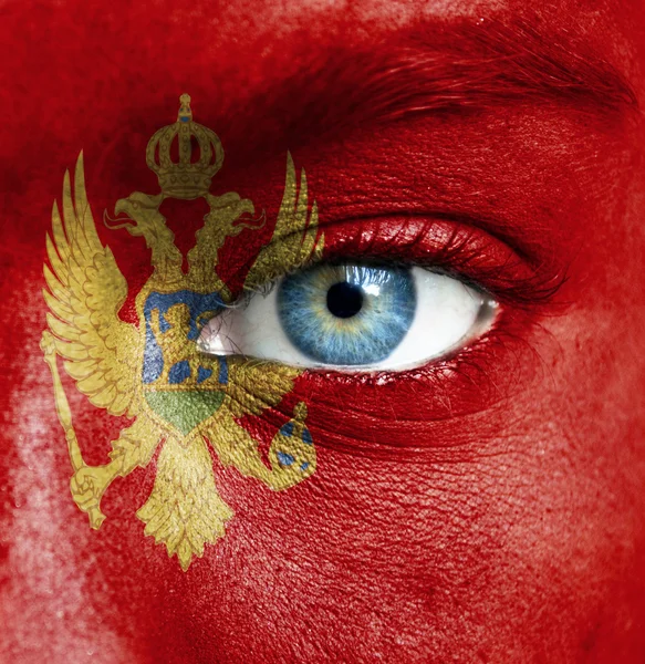 Menschengesicht mit Flagge von Montenegro bemalt — Stockfoto