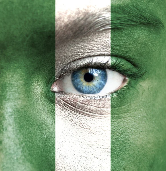 Rosto humano pintado com bandeira da Nigéria — Fotografia de Stock