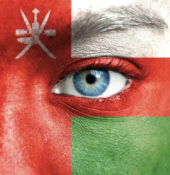 Human face painted with flag of Oman — Stock Photo, Image