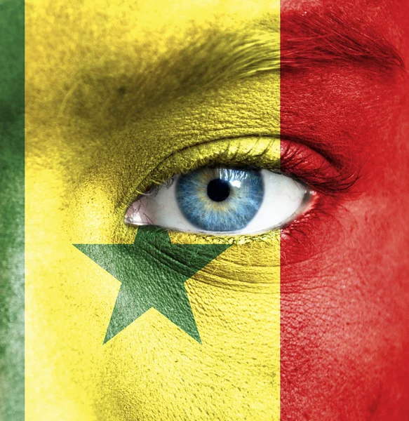 Menschengesicht mit senegalesischer Flagge bemalt — Stockfoto