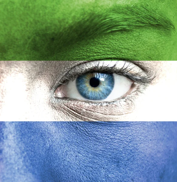 Human face painted with flag of Sierra Leone — Stock Photo, Image