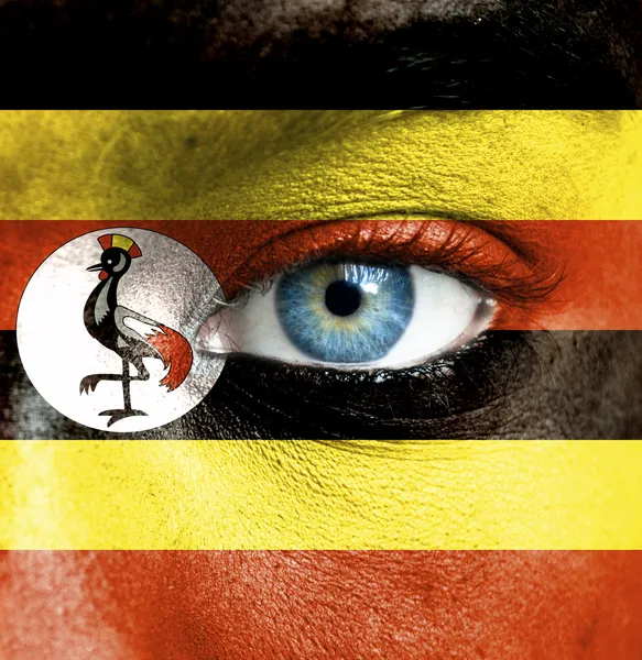 Rosto humano pintado com bandeira de Uganda — Fotografia de Stock