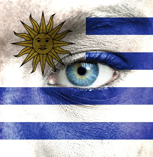 Human face painted with flag of Uruguay — Stock Photo, Image