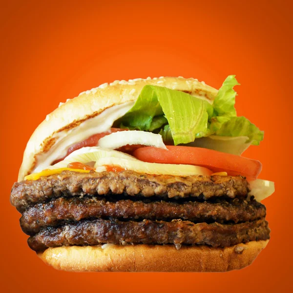 Гамбургер на оранжевом фоне — стоковое фото