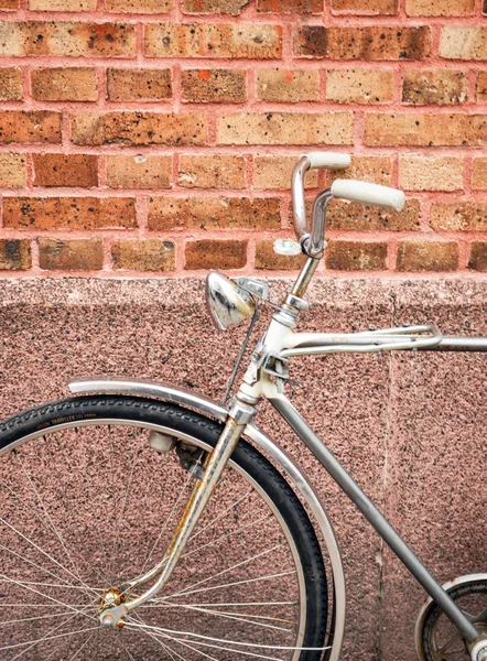 Bicicleta contra detalhe da parede de tijolo — Fotografia de Stock