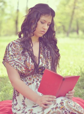 güzel esmer kadının okuma kitabı doğada Retro görüntüsü