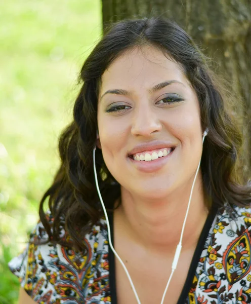 Mulher sorridente bonita ouvindo música ao ar livre — Fotografia de Stock