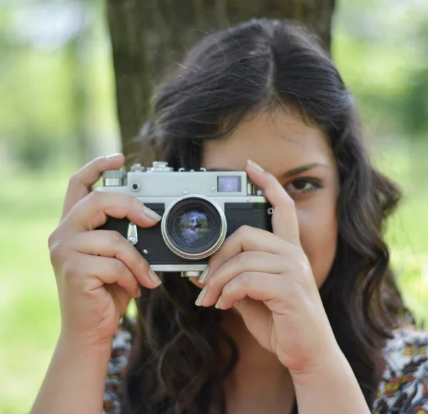 Close up of girl taking photograph with retro camera — Stock Photo, Image