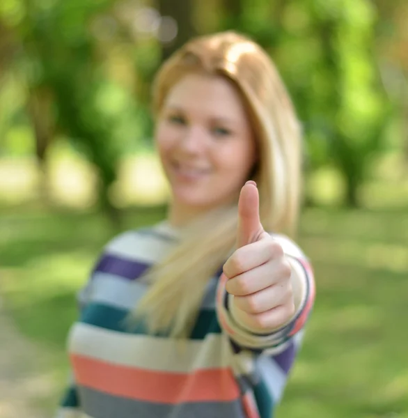 Portrait of girl holding thumb up with focus on thumb — Stock Photo, Image