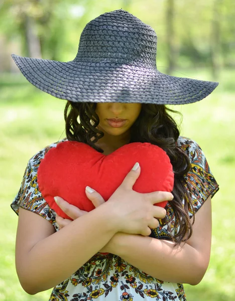 Retrato de niña sosteniendo gran corazón rojo al aire libre — Foto de Stock
