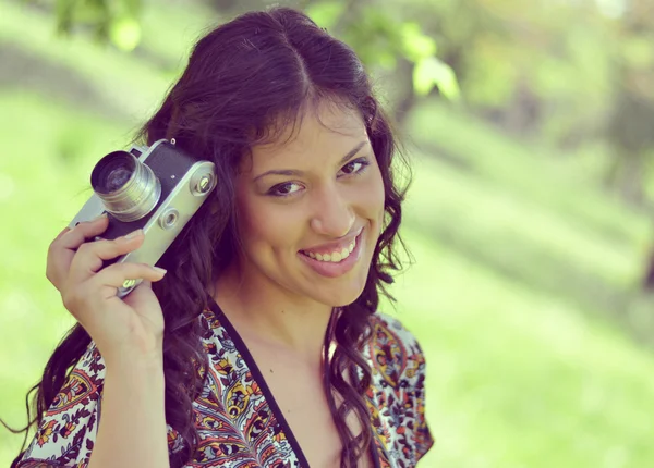Imagen retro de la hermosa mujer sosteniendo la cámara vintage — Foto de Stock
