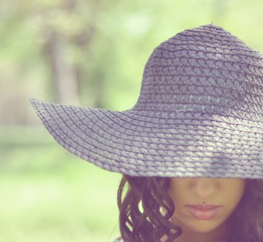 kıvrılmış saçlar ve hasır şapka ile güzel kız portresi ret