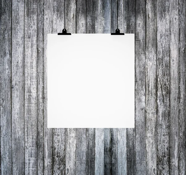 Placa de papel em branco pendurada na parede de madeira grunge — Fotografia de Stock