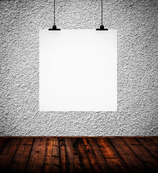Inre av grunge tomt rum med vitboken som hänger på papper — Stockfoto